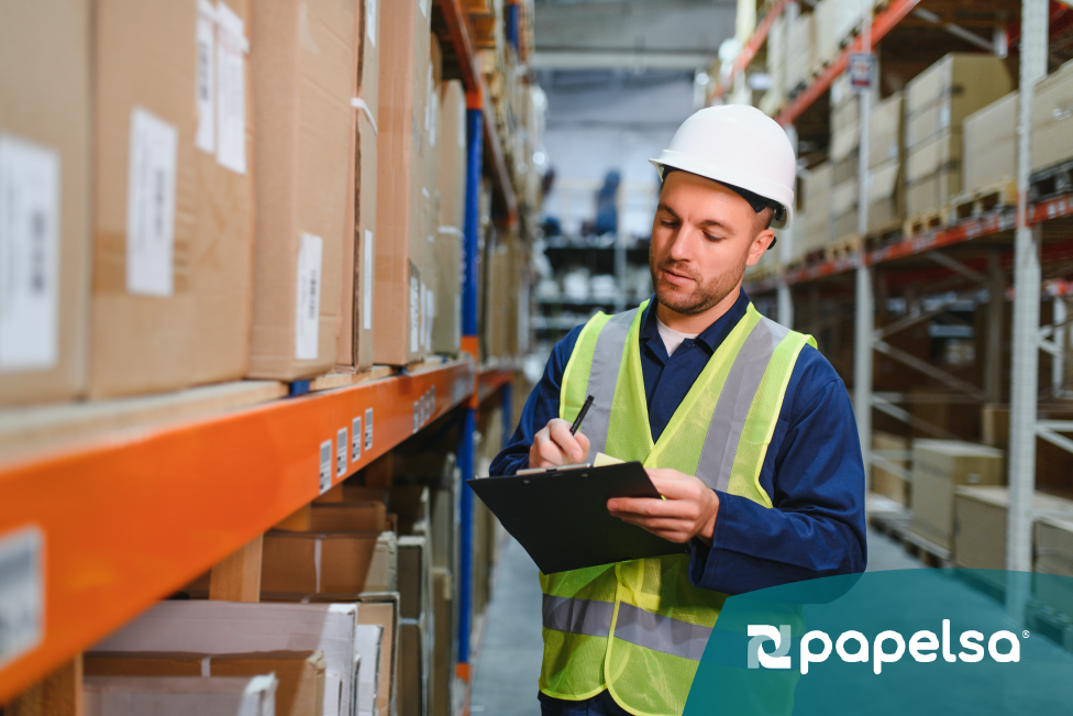 Atributo Alt: Operario revisando inventario de productos para exportación, controlando mercancía con lista de empaque en almacén logístico.