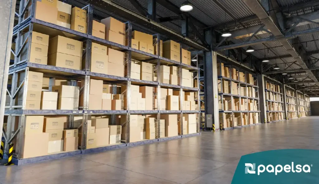 Almacén industrial con estanterías metálicas llenas de cajas de cartón organizadas.