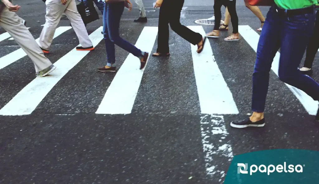 Personas cruzando un paso en una calle urbana.