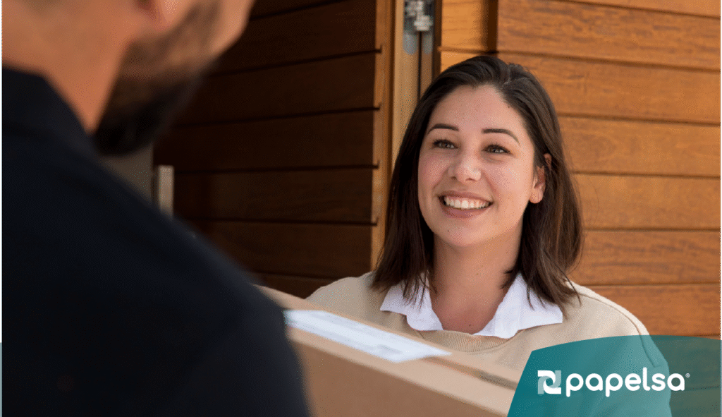 Repartidor entregando cajas de cartón sellada al cliente frente de su casa.