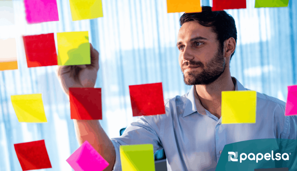 Hombre organizando sus metas y propósitos en papeles de colores.