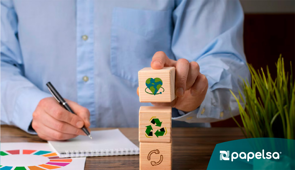 Persona organizando bloques con símbolos de reciclaje y sostenibilidad, representando economía circular y gestión responsable de recursos.