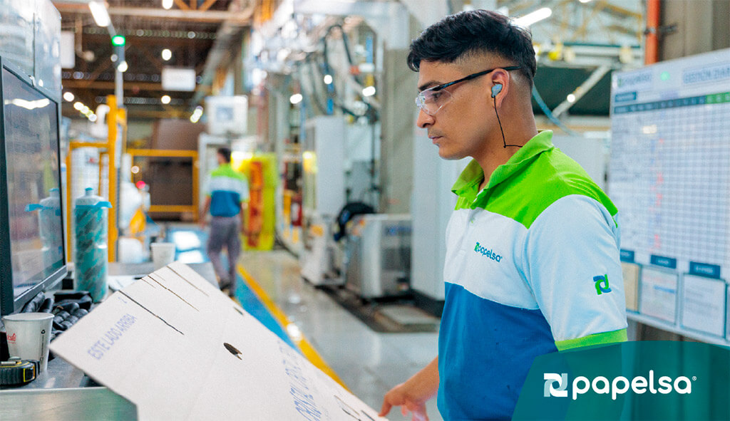 Operador supervisando el diseño estructural de una caja de cartón corrugado.